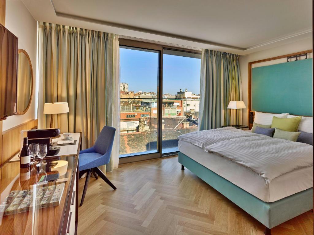 布达佩斯EST Grand Hotel Savoy的酒店客房设有一张床和一个大窗户
