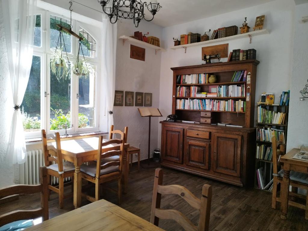 安德纳赫Schmökermühle的一间带桌子和书架的用餐室