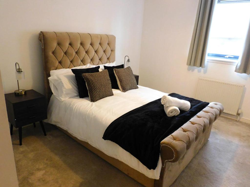 格拉斯哥Fabulous 2 bed apt 10 mins from City Centre的一间卧室配有一张大床,上面有泰迪熊