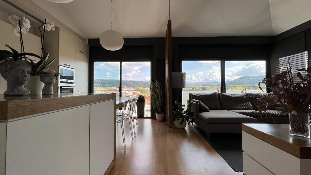 奥洛特Ático de diseño con terraza en el centro de Olot的厨房以及带沙发和窗户的客厅。