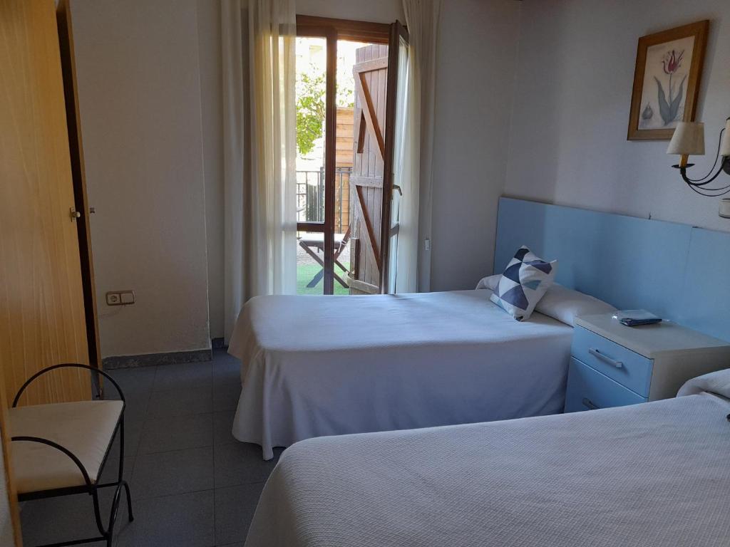 卡斯特洪德索斯卡萨胡安旅馆的酒店客房设有两张床和一个阳台。