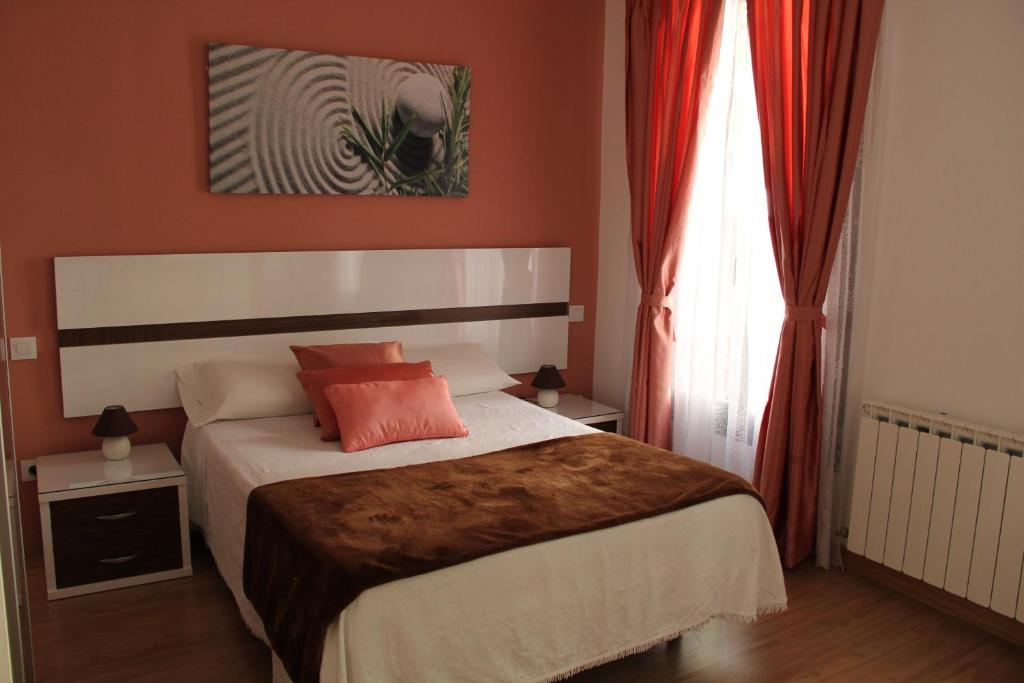 马德里Casa de Huéspedes Galaica的一间卧室配有一张带橙色墙壁和窗户的床