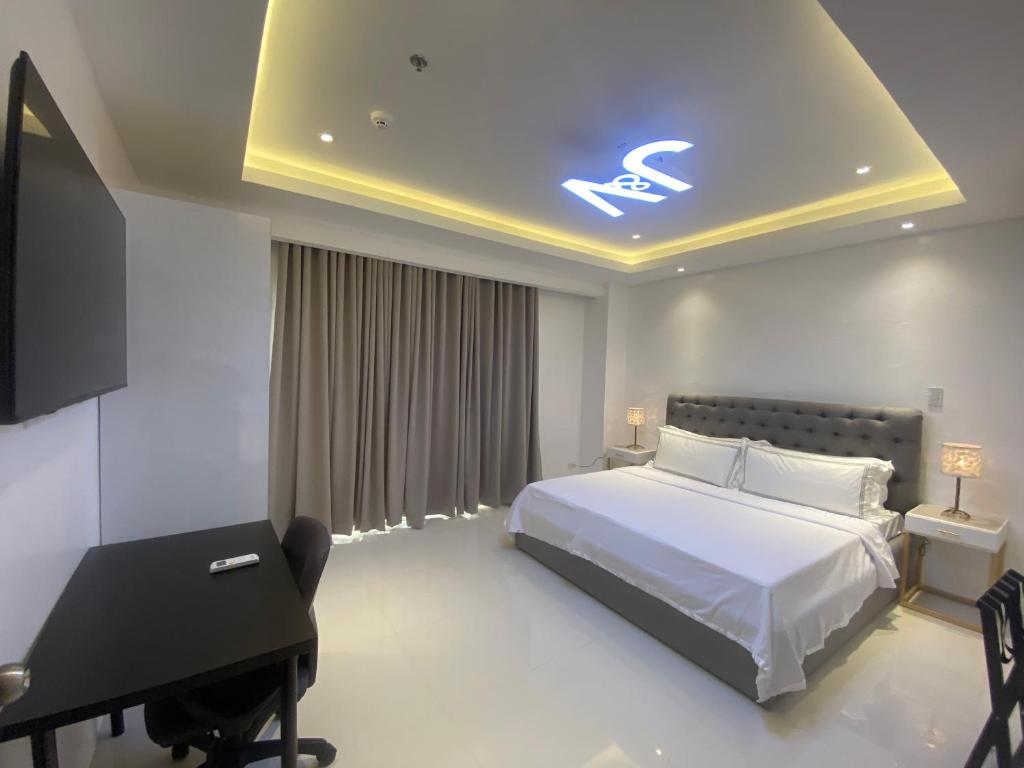 ApalengJ&V Hotel and Resort的卧室配有床、书桌和钢琴