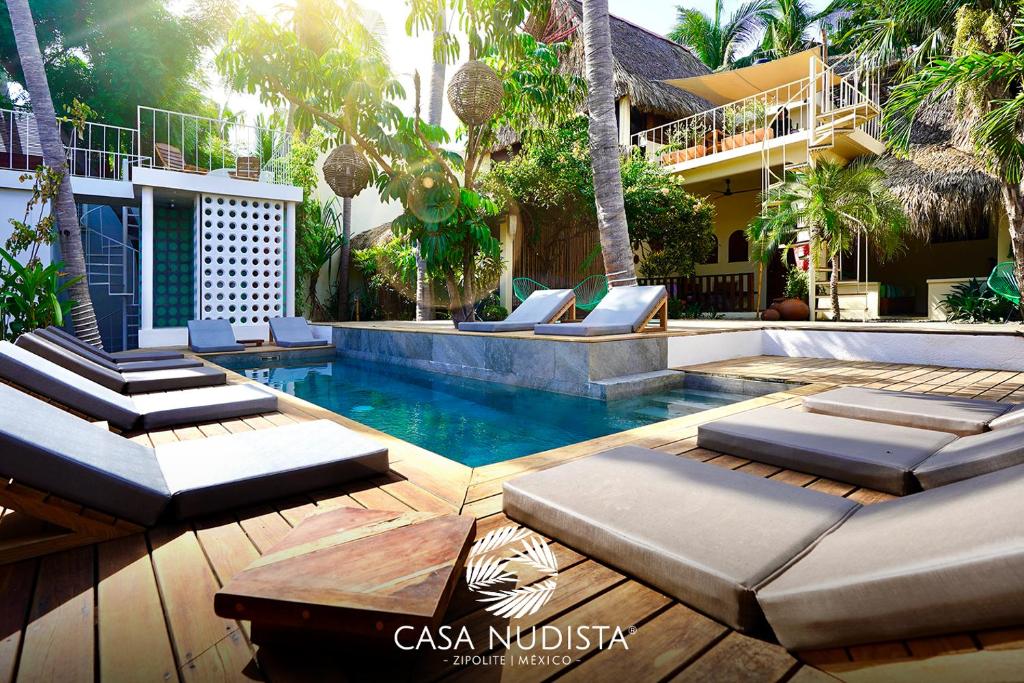兹波利特Casa Nudista - LGBT Hotel的一个带躺椅的游泳池以及一座房子