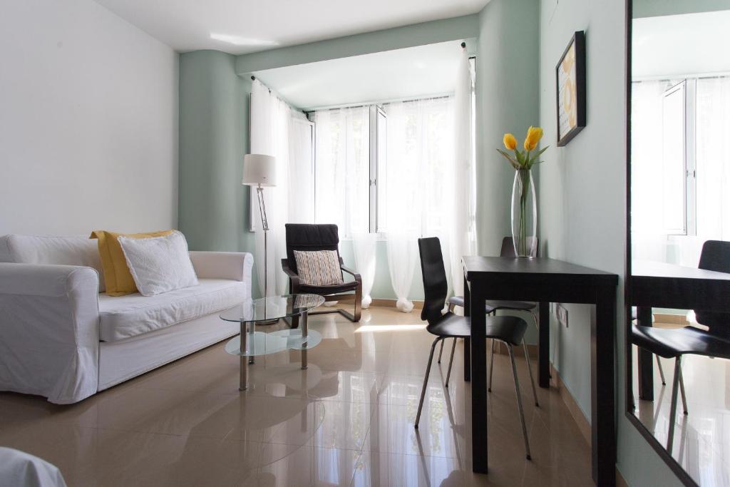 塞维利亚Apartamentos Edificio Constitución的客厅配有白色的沙发和桌子