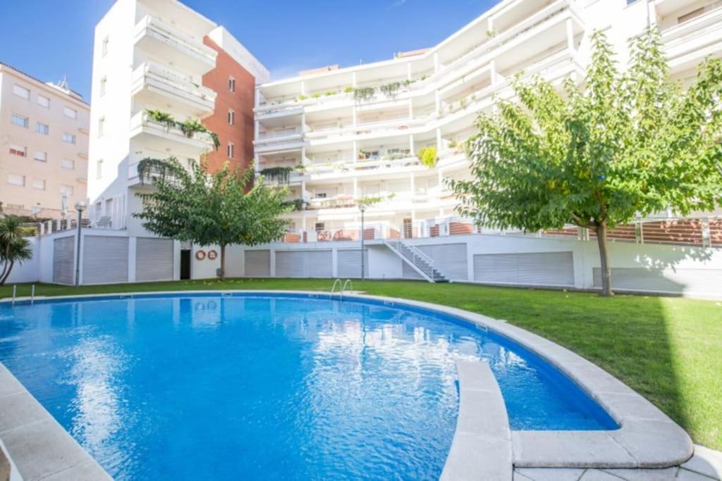 罗列特海岸Precioso apartamento con piscina y jardín propio的大楼前的游泳池