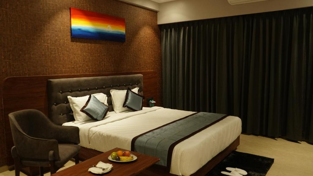 舍地Alaukik Hotel的酒店客房设有一张大床和一张桌子。