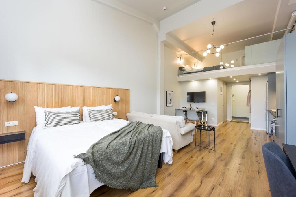 乌普萨拉Foundry Hotel Apartments的卧室配有一张白色大床和一把椅子