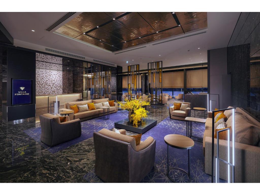 东京Villa Fontaine Premier Haneda Airport的大堂配有沙发、椅子和桌子