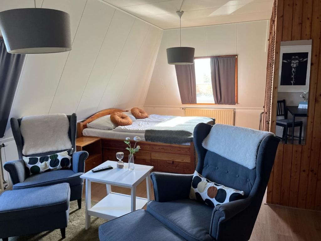 赫鲁斯贝克Hotel De Oude Molen的一间卧室配有一张床、两把椅子和一张桌子