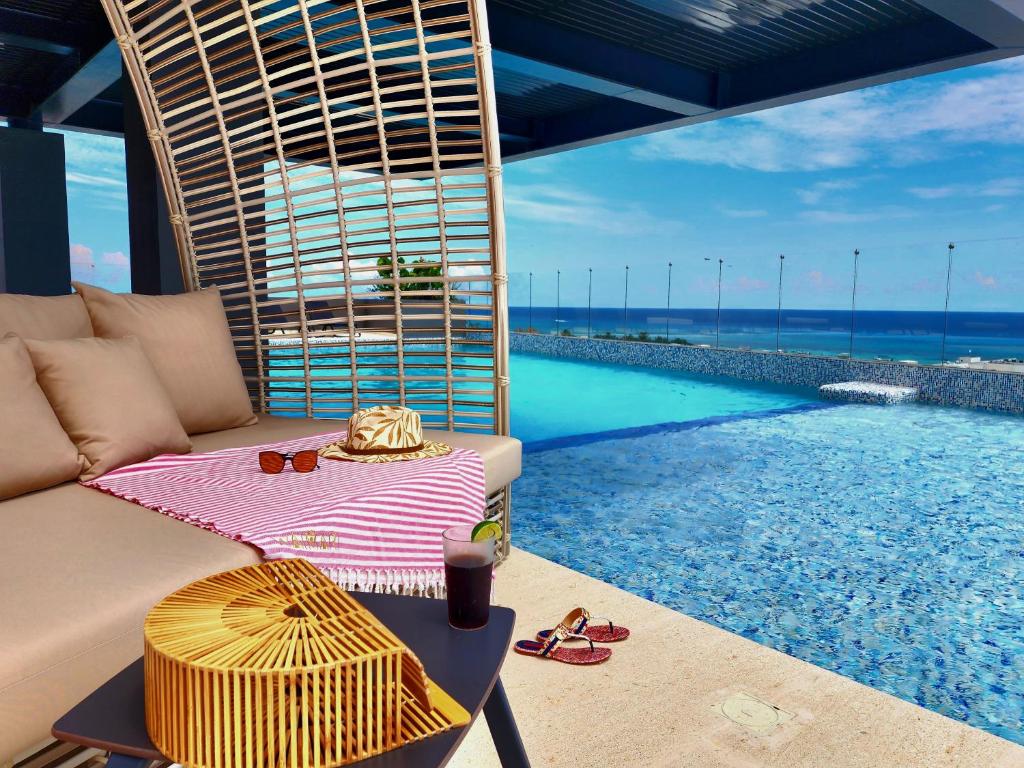 普拉亚卡门Singular Dream Beach Residences的带沙发和游泳池的客厅