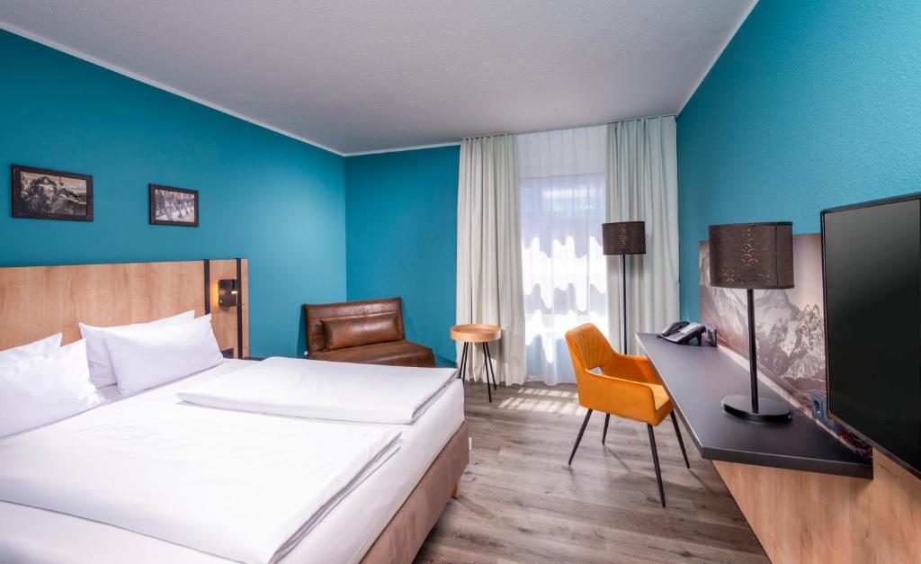 慕尼黑慕尼黑纽佩拉赫索德美居酒店的配有一张床和一张书桌的酒店客房
