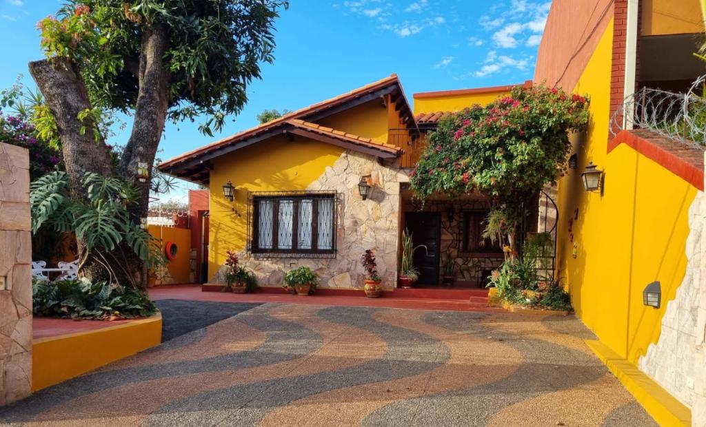 亚松森Mi lugar Vintage Hostal - calor de hogar!的前面有一棵树的黄色房子
