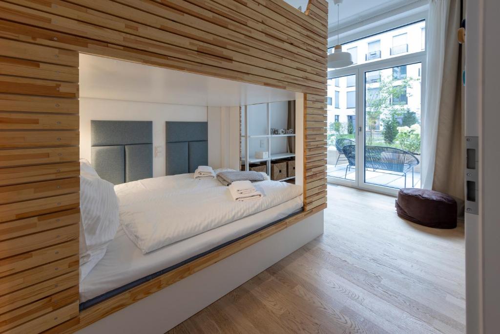 柏林Pure Berlin Apartments - Luxury at Pure Living in City Center的卧室配有一张床铺,位于带木墙的房间内
