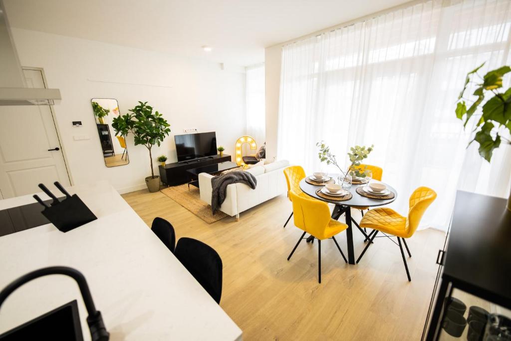 鹿特丹Cheerfully 1 Bedroom Serviced Apartment 52m2 -NB306C-的客厅配有桌子和黄色椅子