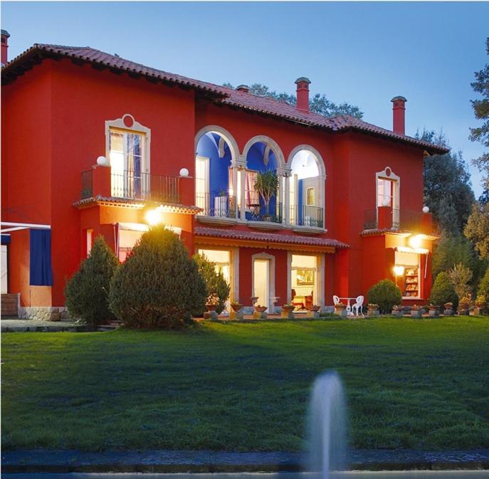 圣朱利亚德维拉托托雷马蒂酒店的一座红色的房子,前面有一个喷泉