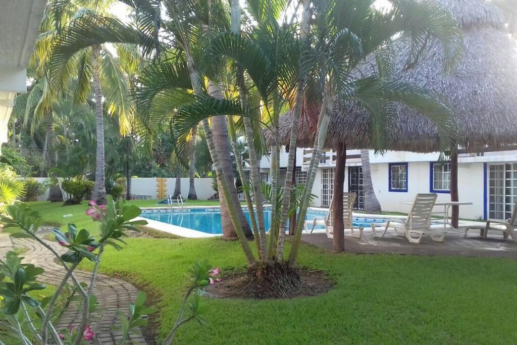 La SabanaCasa en la zona de Acapulco diamante的一个带游泳池和棕榈树的度假村