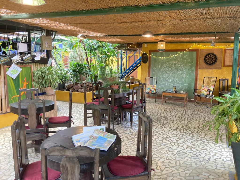 奥罗西Montaña Linda Hostel Orosi的用餐室配有桌椅和黑板