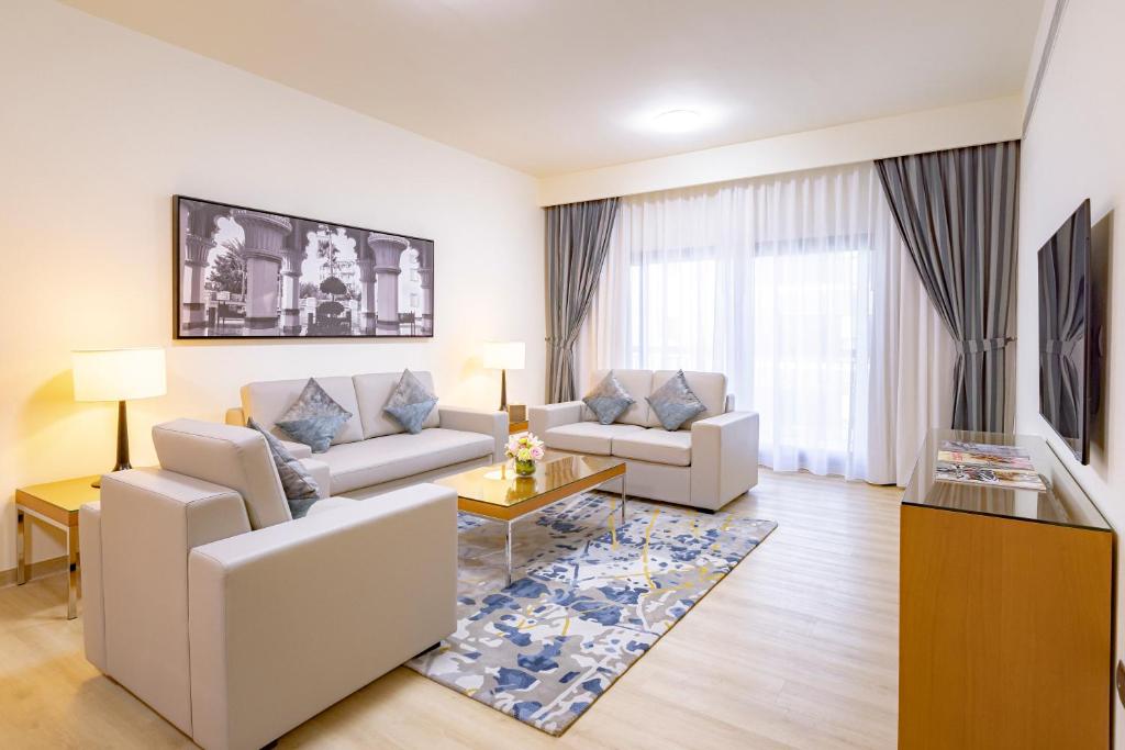 迪拜Golden Sands Suites的客厅配有两张沙发和一张桌子