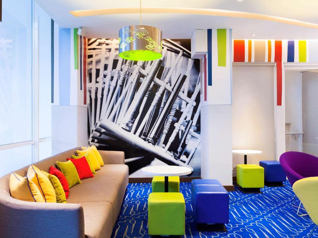 万隆万隆亚非宜必思快捷酒店的客厅配有沙发和五颜六色的椅子