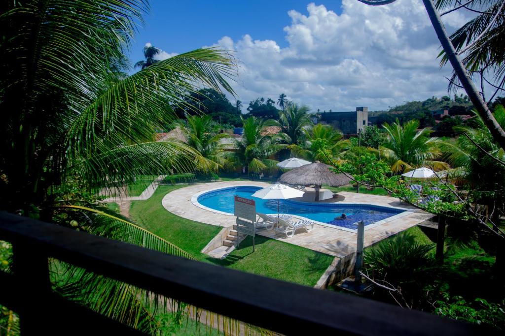 圣米格尔-杜斯米拉格里斯Recanto Caiçara Pousada的享有游泳池和棕榈树的景色