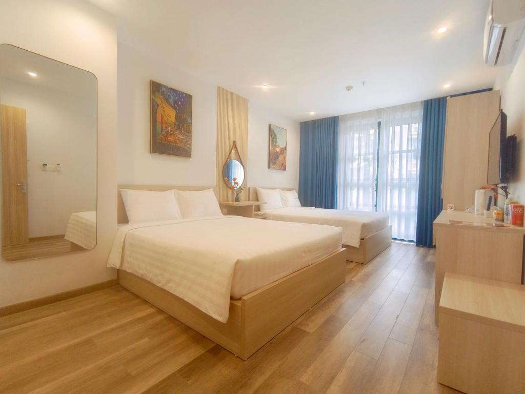 富国Elene Phu Quoc的酒店客房,设有两张床和镜子