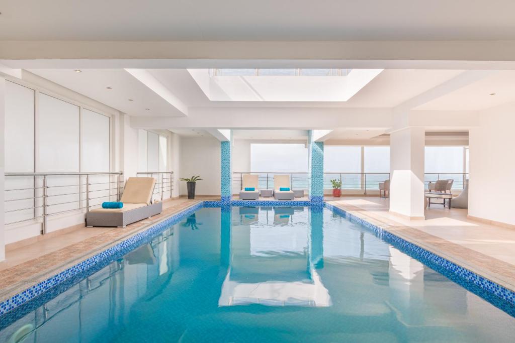锡卜Al Hail Waves Hotel Managed By Centara的大楼里一个蓝色的大泳池