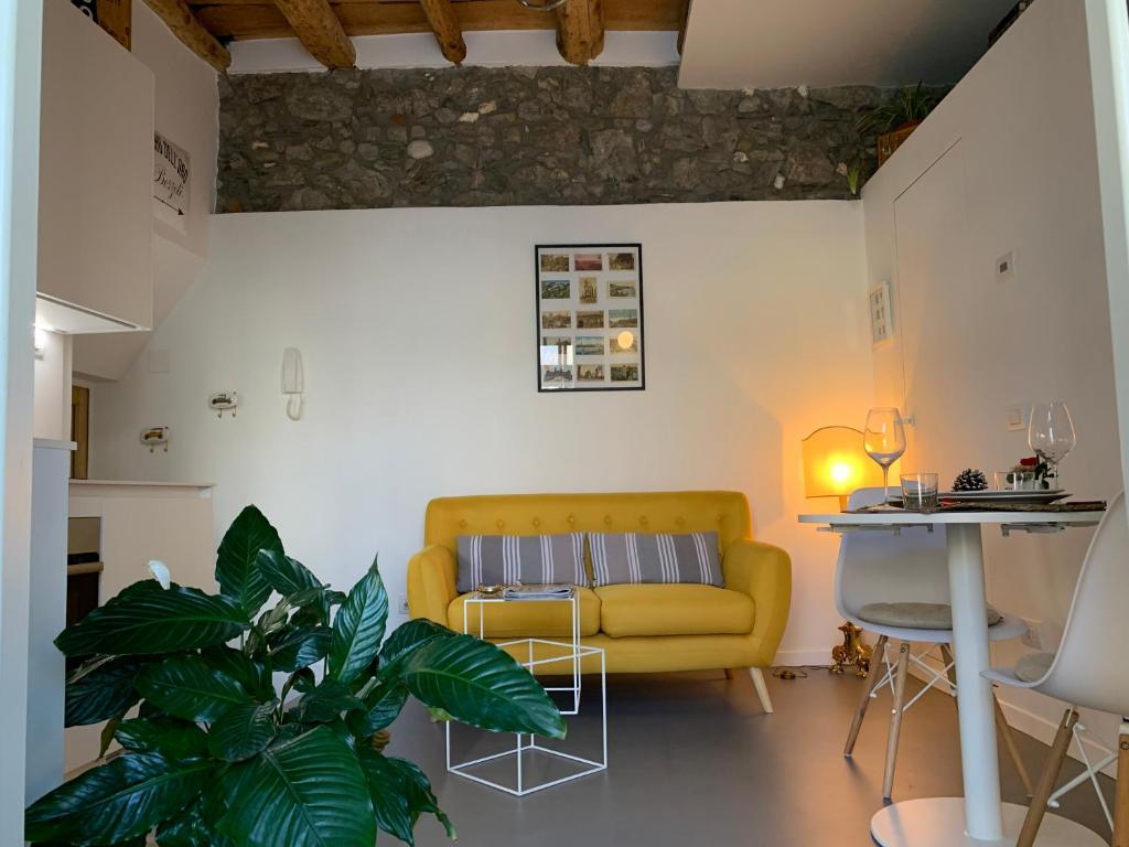 梅纳焦Villa Paola - Holiday Apartment - Menaggio, Lago di Como的客厅配有黄色的沙发和桌子