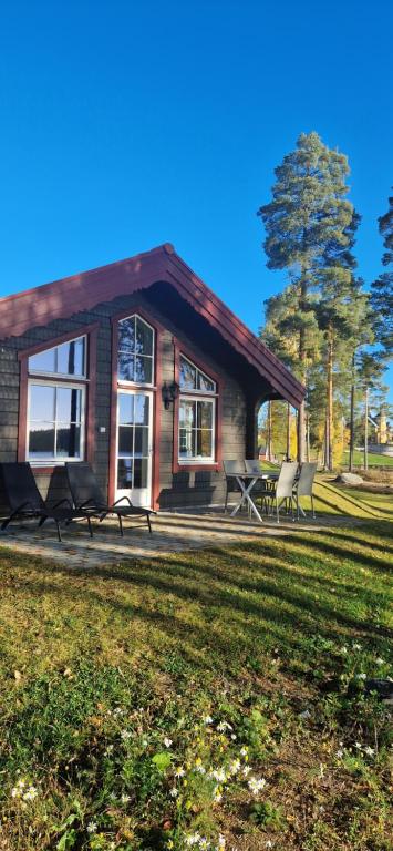 法伦Lakeside log cabin Främby Udde Falun的前面有几把椅子的房子