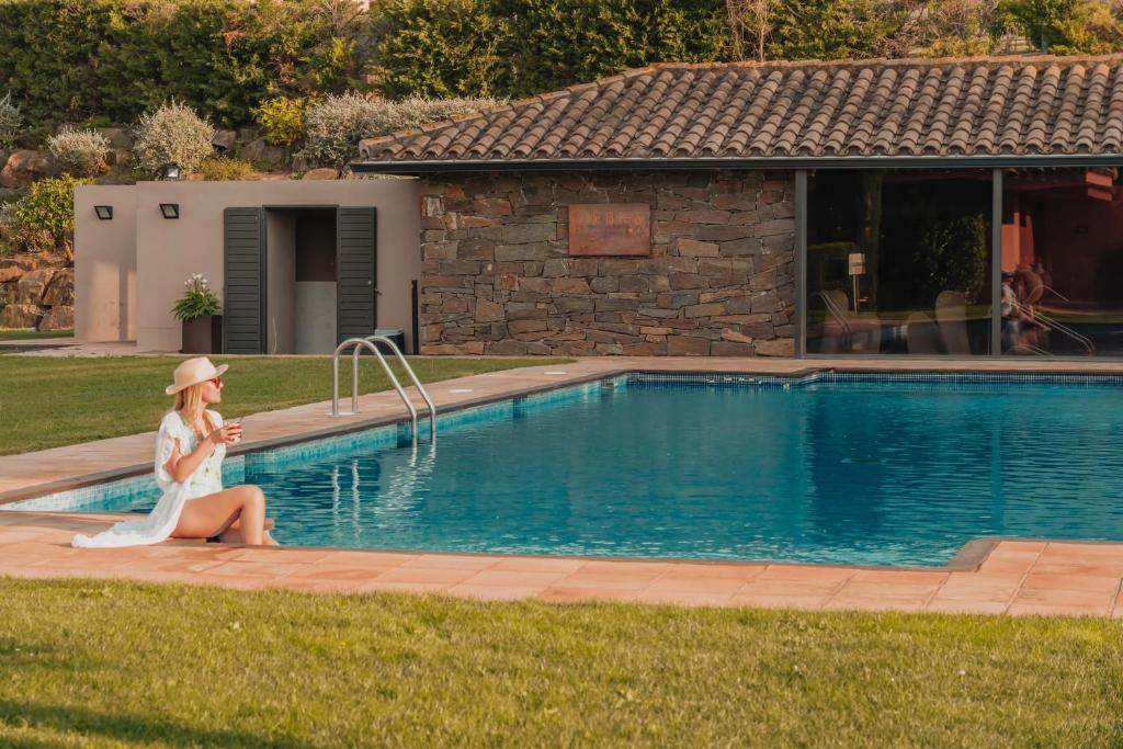 纳瓦拉Hotel TorreMirona Golf & Spa的坐在游泳池旁的女人