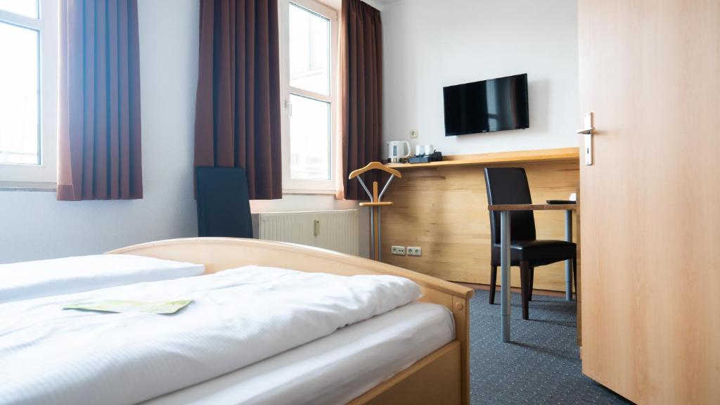 罗斯托克啤酒花市场酒店的配有一张床和一张书桌的酒店客房