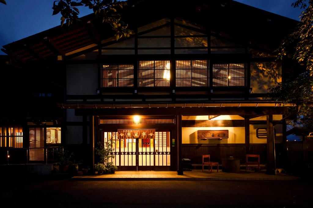 飞騨市布苏特伊酒店的一座建筑物,前门在晚上有照明