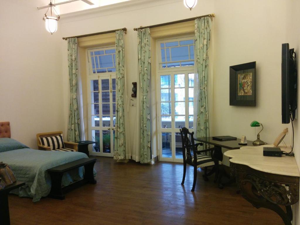 加尔各答哈灵顿住宿加早餐旅馆的卧室配有一张床和一张桌子及椅子