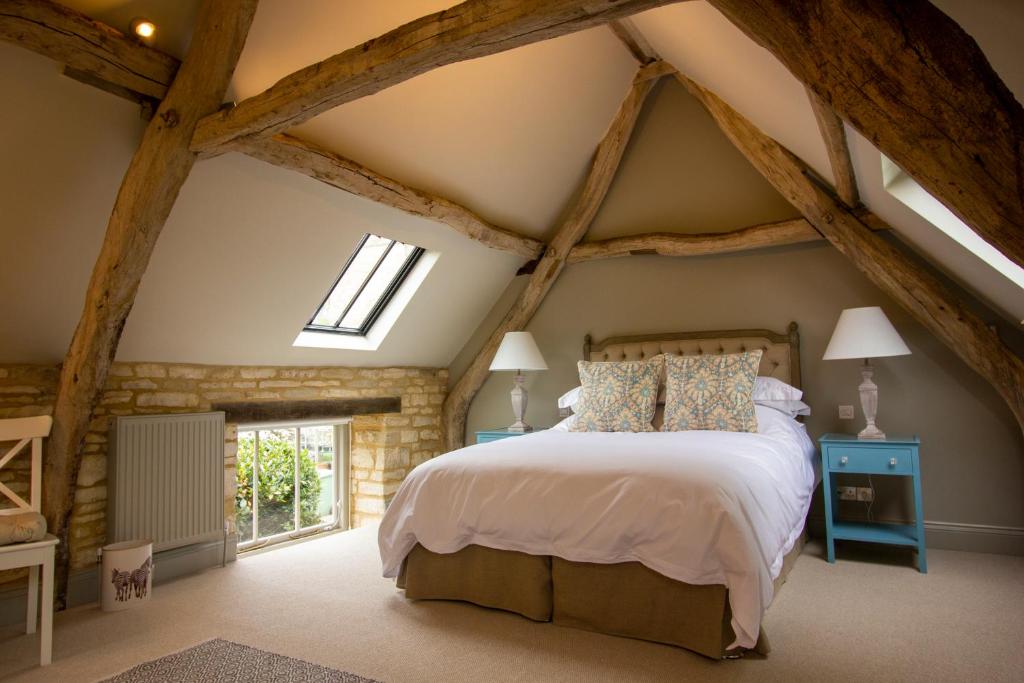 赛伦塞斯特The Potting Shed, 5* Luxury escape Cirencester的一间卧室设有一张大床和外露横梁