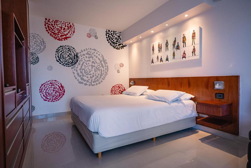 布宜诺斯艾利斯Shoshana Hotel Boutique的卧室设有白色的床和红色及白色的墙壁