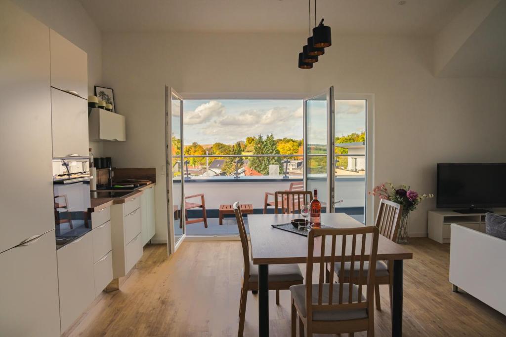 辛斯海姆Panorama Suite 20的厨房以及带桌椅的用餐室。