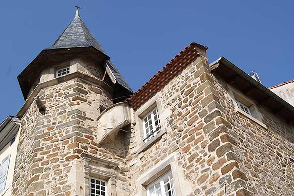 勒布伊Maison au Loup - Superbe ancien hotel particulier du XVIe siècle au cœur de la vieille ville du Puy的一座砖砌建筑,塔楼有屋顶