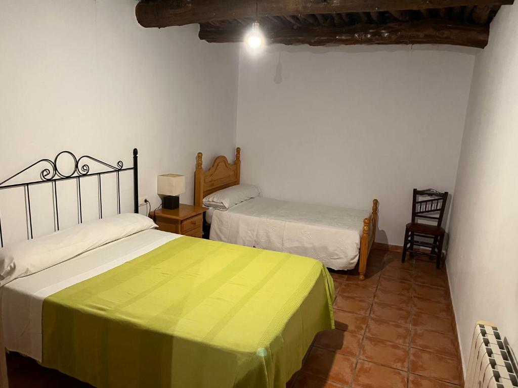 潘潘埃拉CASA M'GUIRE的一间卧室配有两张床、一张桌子和一把椅子