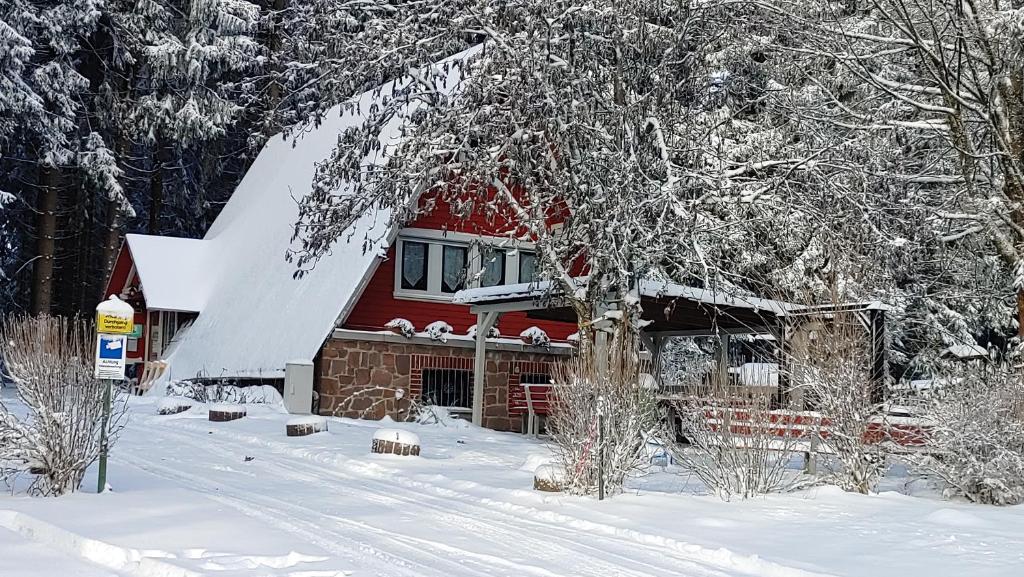 BernhardsthalWanderhütte Zum Bernhardsthal的雪中红房子,有雪覆盖的树木