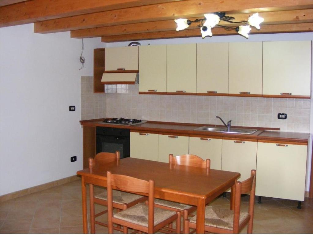 Casole BruzioAntico Borgo的厨房配有木桌、椅子和水槽