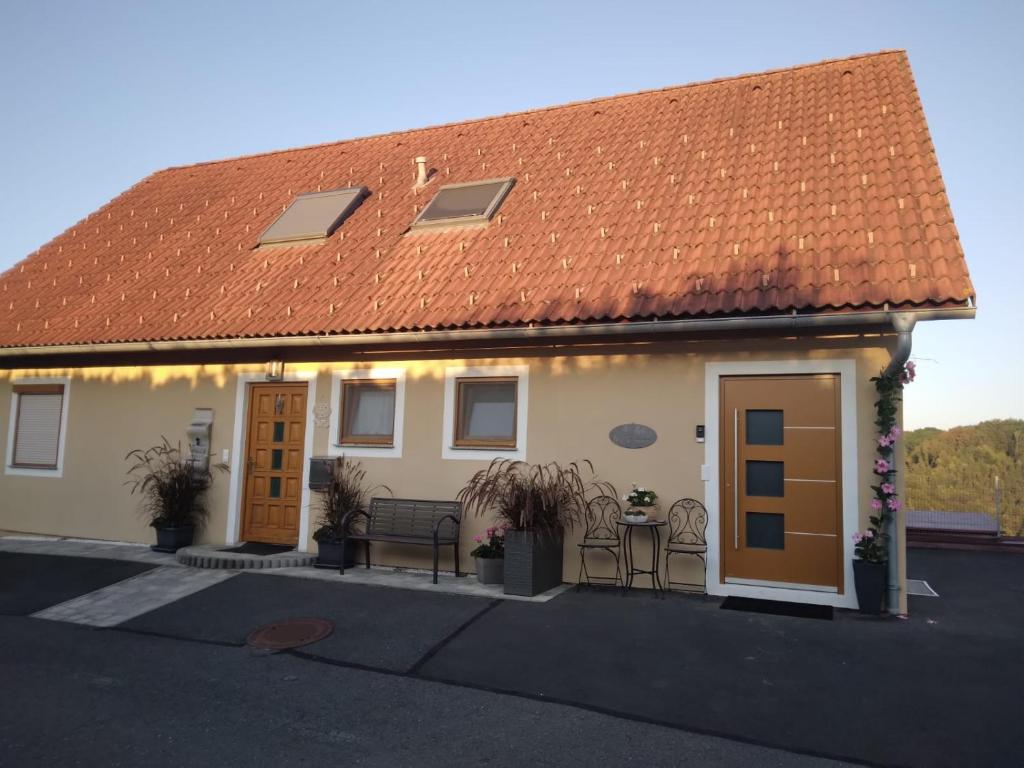 洛伊查赫Appartement Fam.Kremser的白色房子,有橙色的屋顶和两扇门