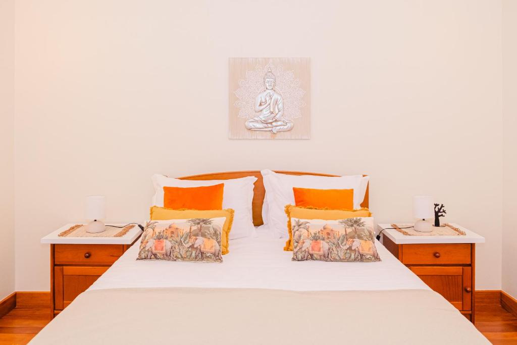 Relógio do PoisoNamastê House I的卧室配有带橙色枕头的白色床