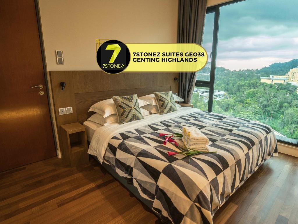 云顶高原7Stonez Suites Geo38 Genting Highlands的酒店客房设有一张带大窗户的床。