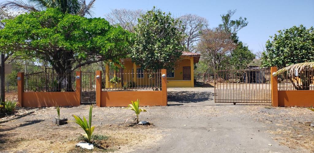 Tonosícabañas playa guanico的黄色房子前面的围栏