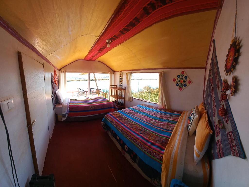 普诺Uros Titicaca Khantaniwa Lodge的小房间设有一张床和一张桌子