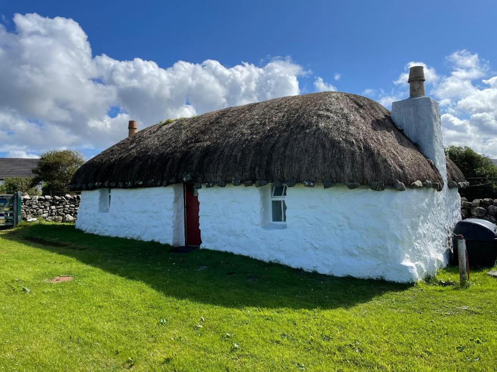 波特里Beaton's Croft House - Uig Skye的古老的白色小屋,设有茅草屋顶