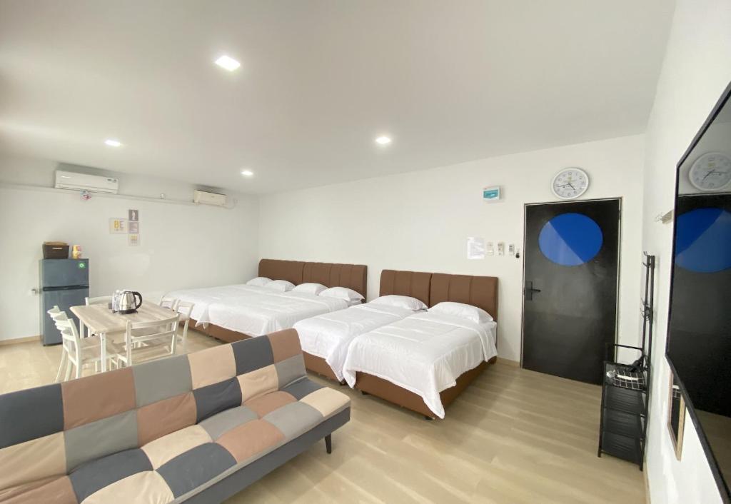 名古屋CN Homestay A3 Floor 1 at Nagoya Hill Mall的一间医院间,配有四张床和一张沙发