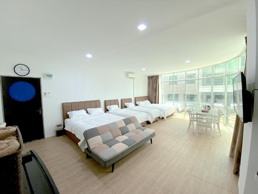 名古屋CN Homestay B2 Floor 2 at Nagoya Hill Mall的一间卧室设有四张床和一张桌子及椅子