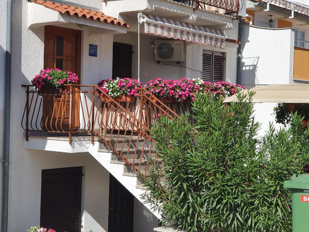 弗尔萨尔Apartments Antolović的一座建筑,设有两个种有鲜花的阳台
