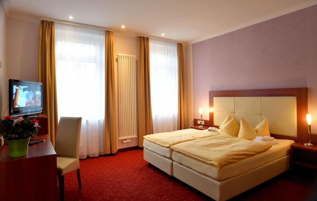 莱比锡莱比锡米特城市酒店的酒店客房,配有床和电视